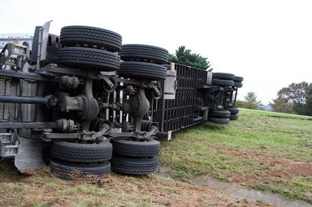 a semi-truck rolled over on the side of the road
